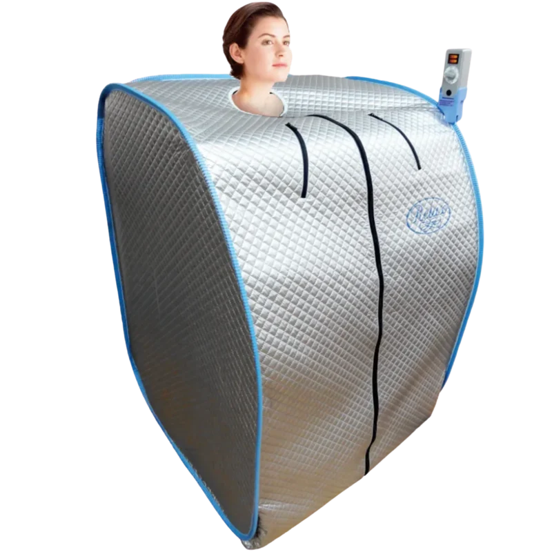 A silver infrared sauna tent with blue trim, featuring a neck opening where a woman's head is visible, along with an attached blue remote control, on a solid white background.